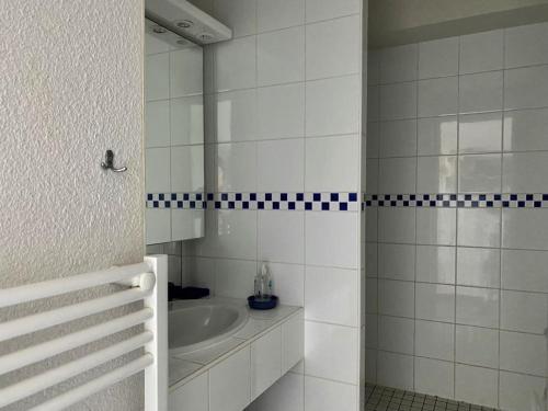 une salle de bain blanche avec un lavabo et un miroir dans l'établissement Appartement sur la plage avec parking privé à Longeville-sur-Mer - FR-1-336-127, à Longeville-sur-Mer