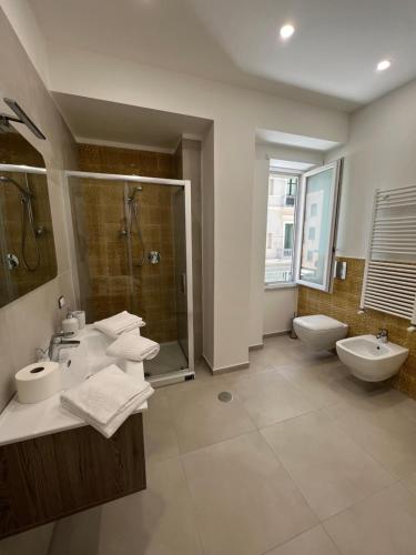 a bathroom with two sinks and a shower and a toilet at Relais Vittorio Veneto - Luxotel & Apartotel in Salerno