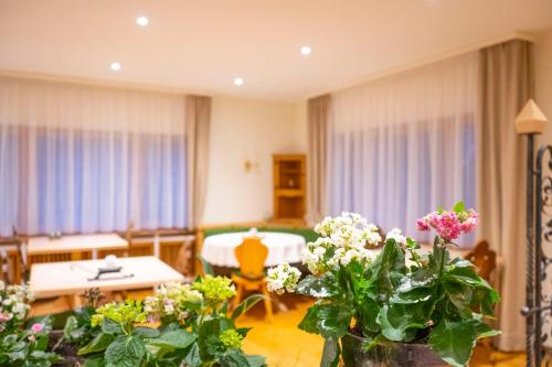 a living room with a table and some flowers at NATURION Hotel Hinterzarten in Hinterzarten