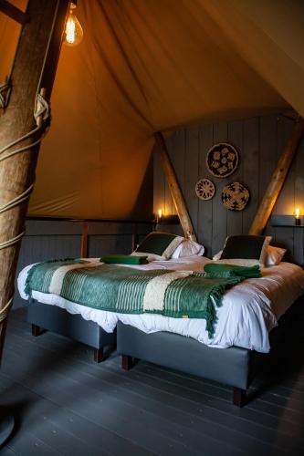 a bedroom with a bed in a tent at Sandberghe - Een plek om te verdwalen in Uden