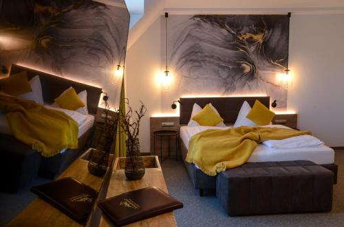a hotel room with two beds and a table at Landhotel Schwabenhof in Heiligenbrunn