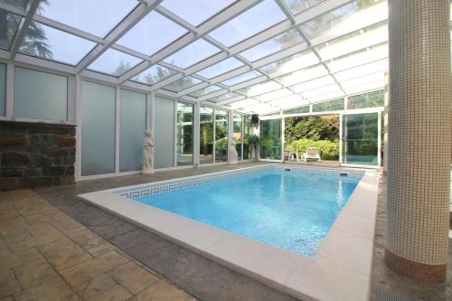 an indoor swimming pool with a glass ceiling at Apartaments Paradise in Koper