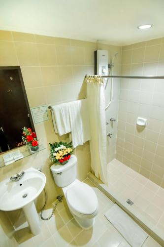 a bathroom with a toilet and a sink and a shower at Rajah Park Hotel by Hiverooms in Cebu City