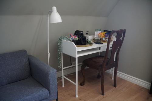 a room with a desk with a chair and a table with at Hotell Stavstensgården in Trelleborg