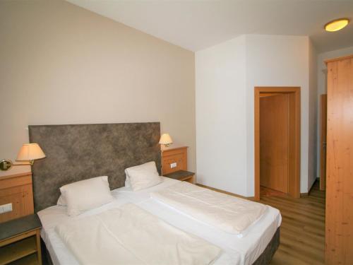 a bedroom with a large white bed with two pillows at Apartment Lechners Wohnwelt-3 by Interhome in Stumm