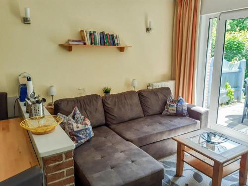ein Wohnzimmer mit einem braunen Sofa und einem Tisch in der Unterkunft Holiday Home Tossens-4 by Interhome in Tossens