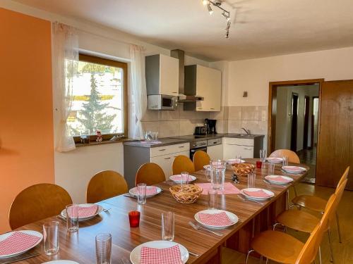 kuchnia z długim drewnianym stołem z krzesłami w obiekcie Apartment Roggenboden-1 by Interhome w mieście Oberau