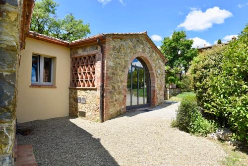 an entrance to a brick building with an archway at Piccolo Borgo Gagnoni in Sinalunga