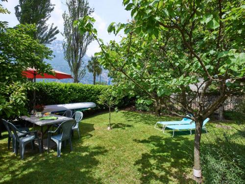ogród ze stołem, krzesłami i deską surfingową w obiekcie Apartment Punto Lago by Interhome w mieście Verceia