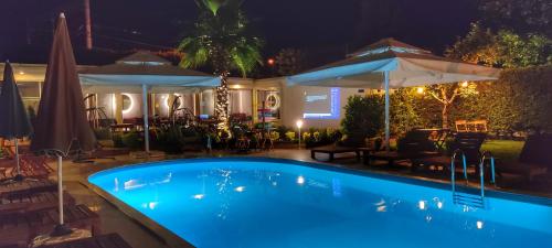 a swimming pool at night with umbrellas at Senler Boutique Hotel in Sapanca