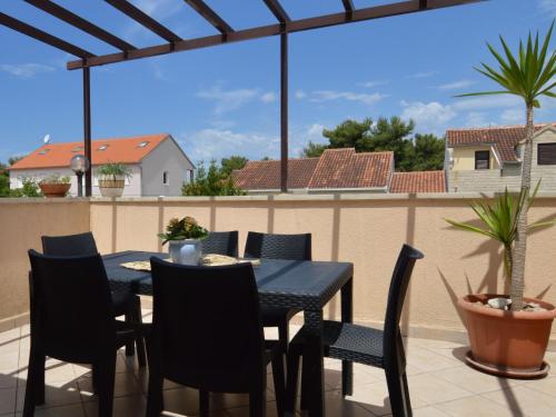 a black dining table and chairs on a balcony at Apartment Mira-2 by Interhome in Mirce