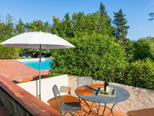 een tafel en stoelen met een parasol naast een zwembad bij Holiday Home Bardeggiano - Caterina 6 by Interhome in Belvedere