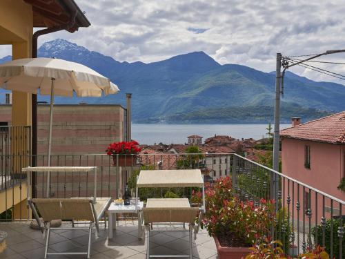 a balcony with a table and chairs and a view of the mountains at Holiday Home Pieve - GRV102 by Interhome in Gravedona