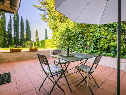 a table with two chairs and an umbrella on a patio at Holiday Home Bardeggiano - Caterina 8 - COL243 by Interhome in Belvedere