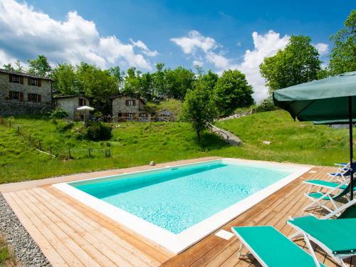una piscina en una terraza de madera con sillas alrededor en Holiday Home Paradiso II by Interhome, en Bolognana