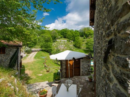 an external view of a stone building with a table and umbrella at Holiday Home Paradiso II by Interhome in Bolognana