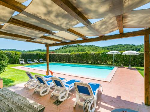 eine Terrasse mit Stühlen und einem Pool in der Unterkunft Apartment Casolare Bretulla-2 by Interhome in Tresanti