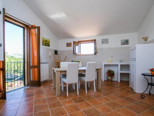 a kitchen and dining room with a table and white chairs at Holiday Home Metallo by Interhome in Colle Val D'Elsa