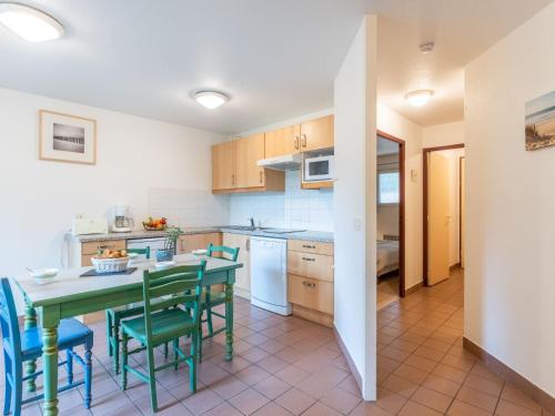 une cuisine avec une table et des chaises vertes dans l'établissement Apartment Village Cheval Spa Résidences-4 by Interhome, à Lacanau-Océan
