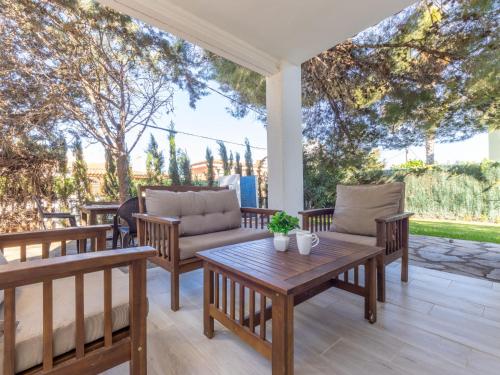 un patio con sillas de madera y una mesa. en Holiday Home Cornelia Pucho by Interhome en Cambrils