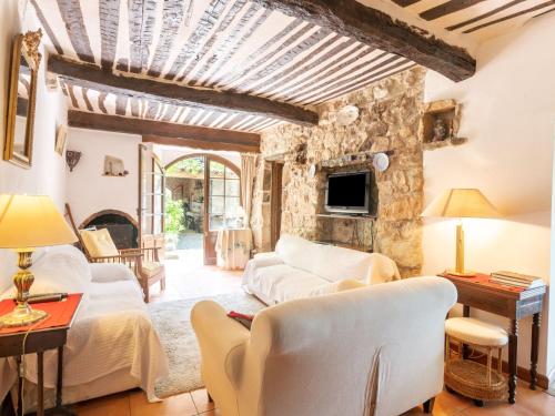 a living room with white furniture and a stone wall at Holiday Home Les Ondes by Interhome in Saint-Jean-du-Gard