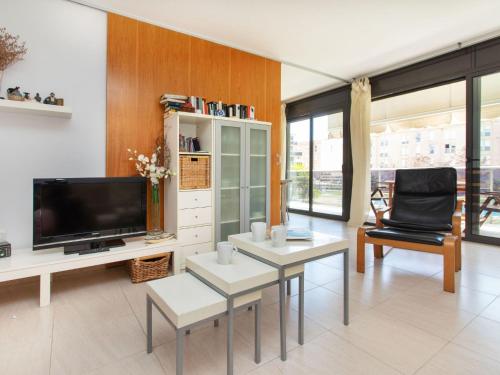 sala de estar con TV, mesa y sillas en Apartment El Jardi del Mar, en Sant Antoni de Calonge