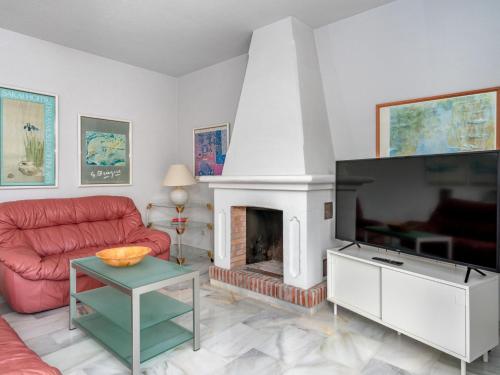 sala de estar con chimenea y sofá rojo en Villa Querida by Interhome, en Mijas Costa