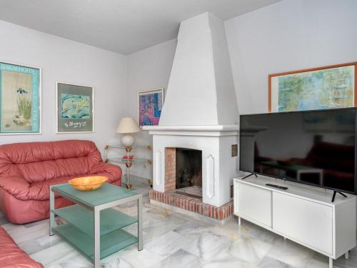 a living room with a fireplace and a red couch at Villa Querida by Interhome in Mijas Costa