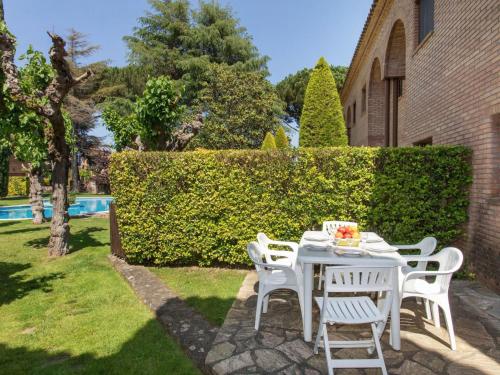 a white table and chairs in the yard of a house at Holiday Home Club by Interhome in Calonge