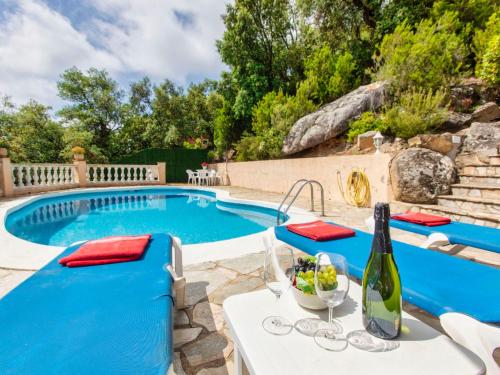 a pool with a table and chairs and a bottle of wine at Holiday Home Bella Vista by Interhome in Calonge