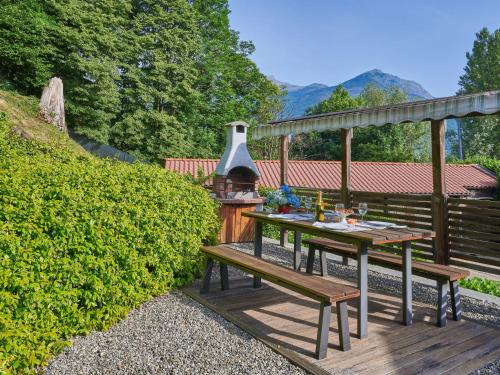 eine Holzterrasse mit einem Picknicktisch und einem Grill in der Unterkunft Holiday Home Letizia by Interhome in Cresciasca