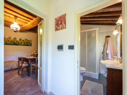 a bathroom with a sink and a toilet and a table at Holiday Home Vittorio by Interhome in Montorgiali