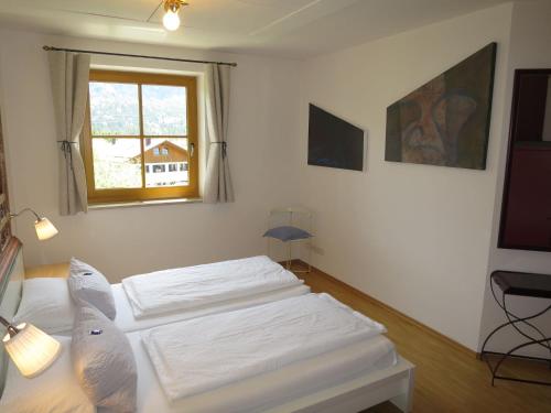 2 witte bedden in een kamer met een raam bij Apartment Flösserstrasse by Interhome in Wallgau