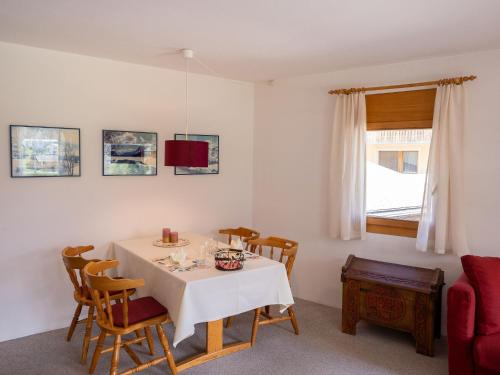a dining room with a table and chairs and a window at Apartment Chesa Pra d`Sura 217-10 by Interhome in Maloja