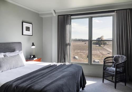 a bedroom with a bed and a large window at Cleveland Estate in Lancefield