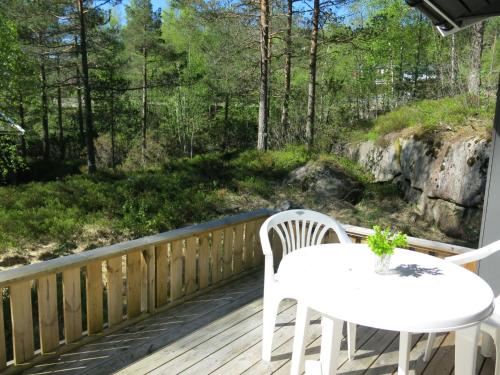 a patio with a table and chairs on a deck at Holiday Home Torsteinbu - SOW118 by Interhome in Øyuvstad