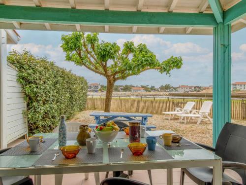 a table on a patio with a view of a tree at Holiday Home Le Hameau des Pêcheurs 5-1 by Interhome in Mimizan-Plage