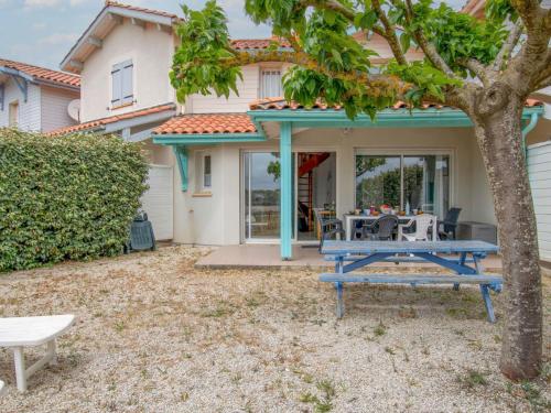 a patio with a blue picnic table in front of a house at Holiday Home Le Hameau des Pêcheurs 5-1 by Interhome in Mimizan-Plage