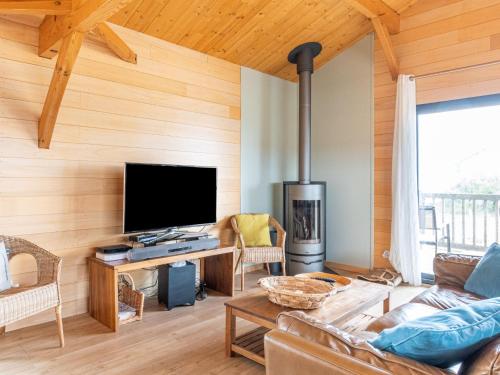 Una sala de estar con televisión y chimenea. en Holiday Home Les Mouettes by Interhome, en Mimizan-Plage