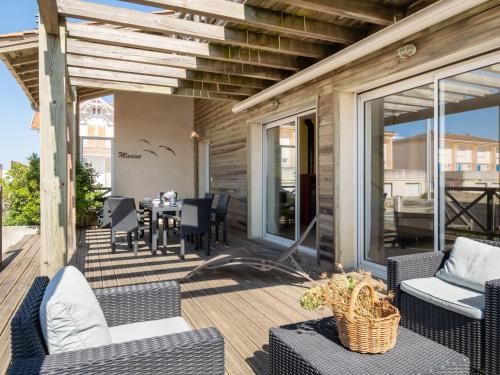 an outdoor patio with wicker chairs and a table at Holiday Home Villa Marine by Interhome in Mimizan-Plage