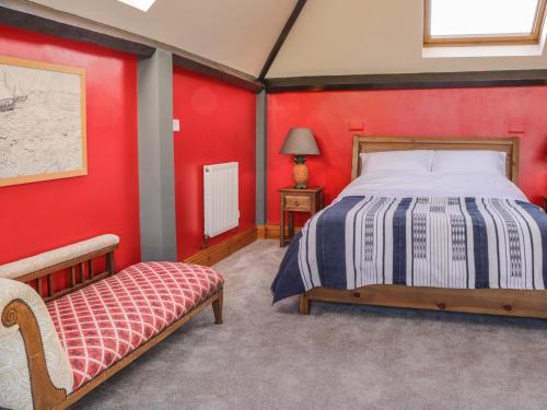 1 dormitorio con cama y pared roja en Atelier, en Bridlington