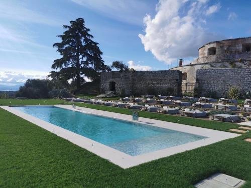 a large swimming pool in front of a castle at Relais Forte Benedek Wine & SPA - Adults Only in Pastrengo