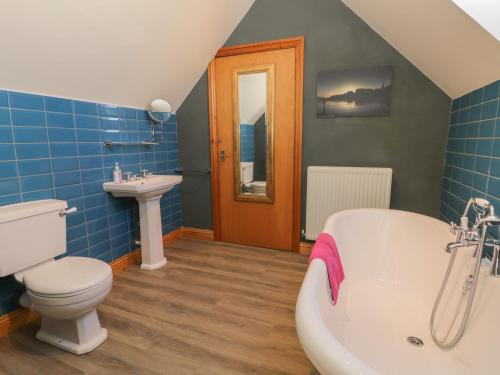 uma casa de banho com uma banheira, um WC e um lavatório. em Atelier em Bridlington