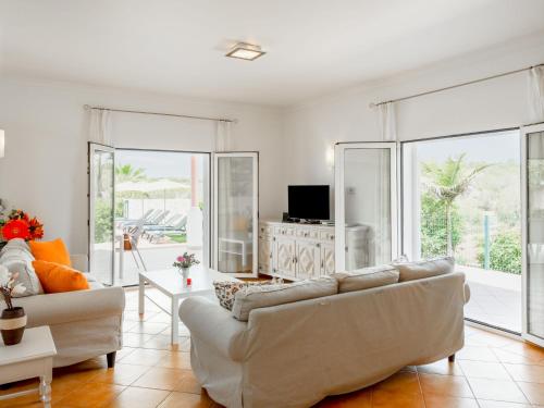 a living room with white furniture and large windows at Villa Villa Pescada by Interhome in Albufeira