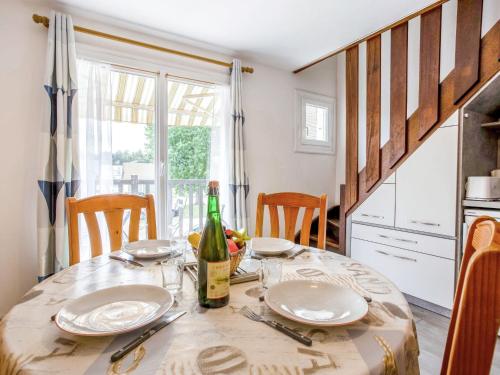 - une table avec des assiettes et une bouteille de vin dans l'établissement Apartment La Côte Fleurie-3 by Interhome, à Merville-Franceville-Plage