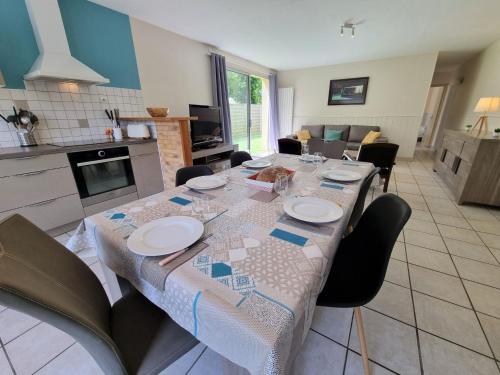 une table de salle à manger avec des chaises et une cuisine dans l'établissement Holiday Home Lamomali by Interhome, à Lancieux