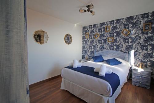 a bedroom with a large bed with blue pillows at LA MAR SALADA in Lastres