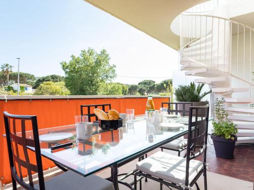 une table et des chaises sur une terrasse avec un mur orange dans l'établissement Apartment Les Patios-7 by Interhome, à Saint-Tropez