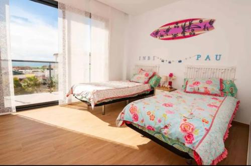 sypialnia z 2 łóżkami i dużym oknem w obiekcie Villa Torre Paraíso w mieście Torrox