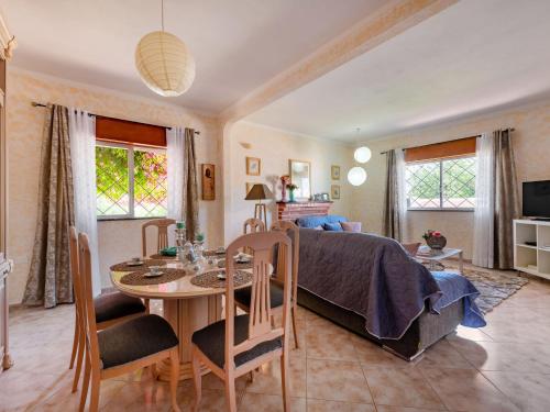 a bedroom with a bed and a table and a dining room at Holiday Home Isaurinda by Interhome in Faro
